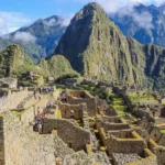Ciudadela de Machu Picchu entre nubes vista desde la terraza principal, tour Peru 8 dias