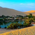 Oasis de Huacachina con dunas de arena e laguna en Ica Peru, sandboarding